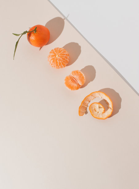 创造性的背景与新鲜的橘子或橙色在柔和的米色背景。图片下载