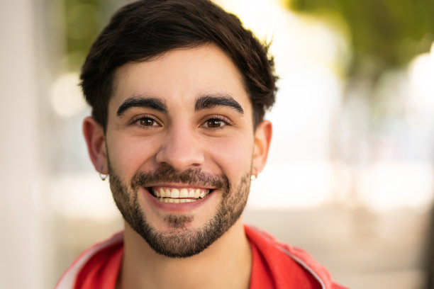 年轻男子在户外微笑的特写。图片下载