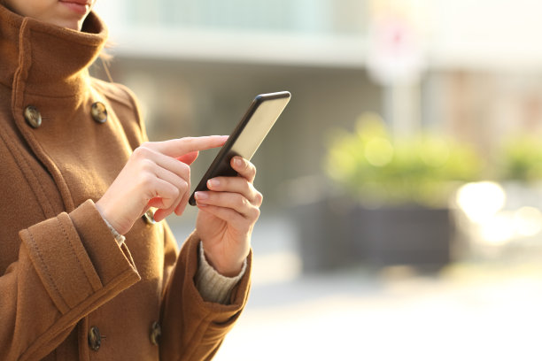 女人在冬天用智能手机在街上双手图片下载
