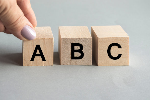 女性手里拿着一个立方体，字母单词就放在木方上，回到学校概念，学习阅读的基本知识图片下载