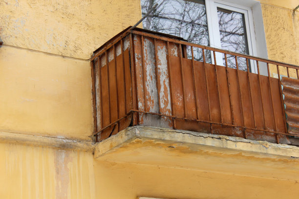 老阳台上一堵锈迹斑斑的亮黄色墙，危险损坏图片下载