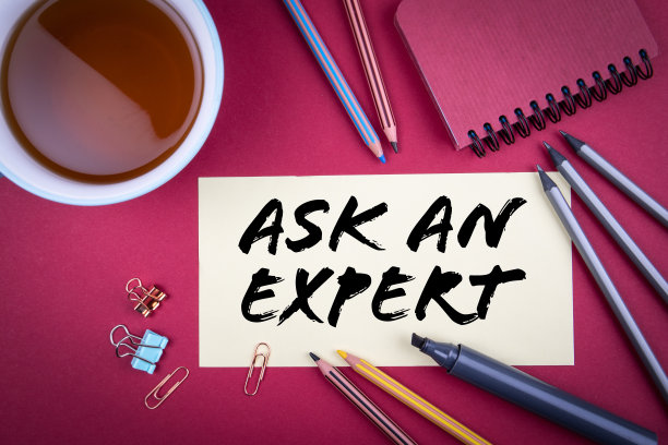 问一个专家。茶杯和办公用品放在红色的桌子上图片下载