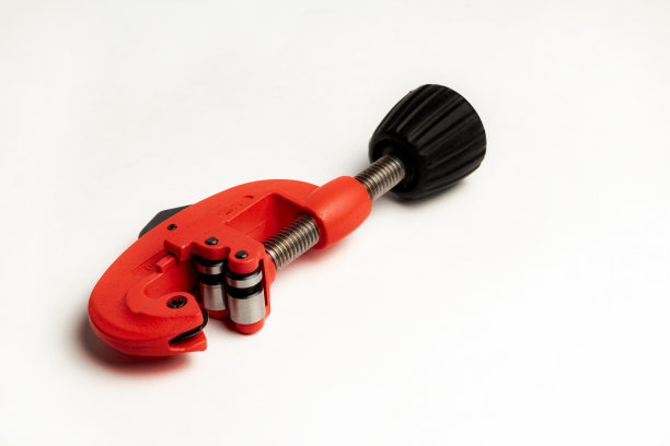 在白色背景上切割管道的红色管道工工具图片下载