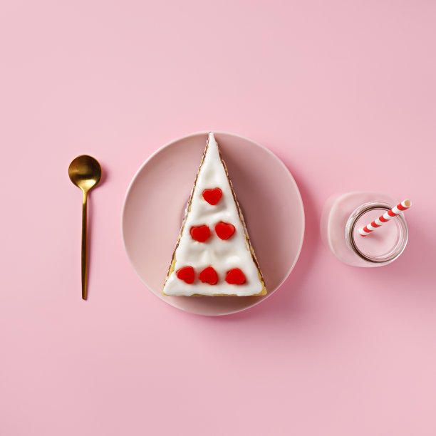 用心形糖衣、金色勺子、粉色背景上的饮料瓶做的甜点蛋糕的爱的布局图片下载