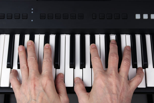 人在合成器的键盘上弹奏图片下载