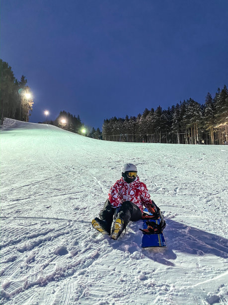 滑雪基地,度假胜地。戴着头盔戴着滑雪板从山上骑下来的年轻女子图片下载