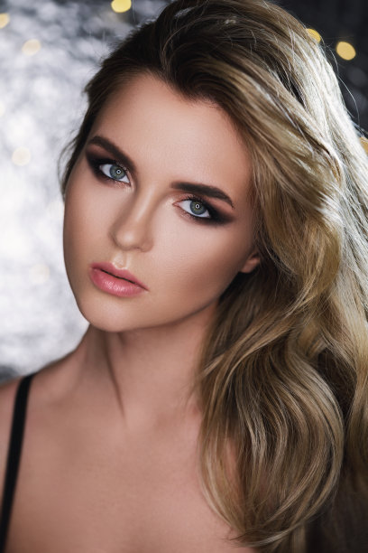 漂亮的女人，一头漂亮的卷发和专业的妆容图片下载