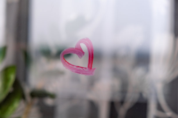 用口红画在玻璃上的心。圣情人节。爱和浪漫。用口红画的心。窗口图片下载