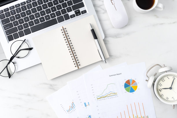 办公桌边，大理石白色背景上的空白笔记本，报告和闹钟。图片下载