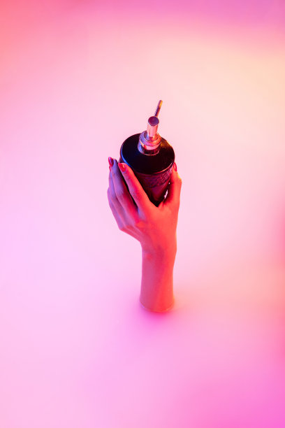 近女性的手从牛奶浴与柔和的霓虹灯发光手势图片下载