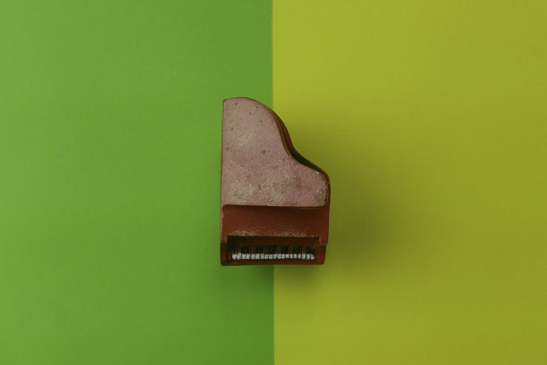 顶视图的红色玩具钢琴上的两种颜色的背景是绿色和黄色。图片下载