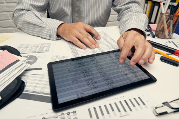 商业分析和会计概念-商人与文件，电子表格，使用计算器，平板电脑。的办公桌上特写镜头。图片下载