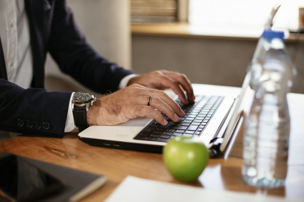 男子的手在笔记本电脑上工作的特写。图片下载