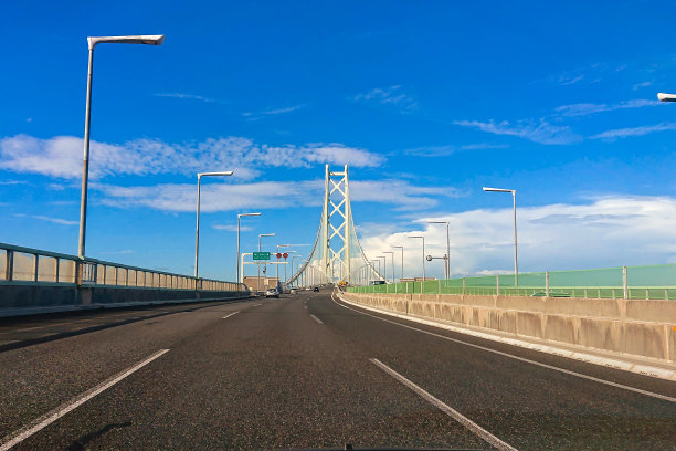 在阳光明媚的日子里，开车经过明石海峡大桥图片下载