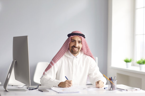 平静的阿拉伯男人坐在办公室的桌旁图片下载