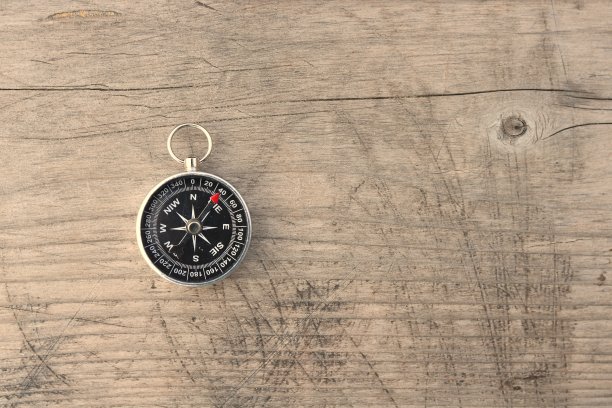 木制背景上的圆规作为旅游罗盘的象征图片下载
