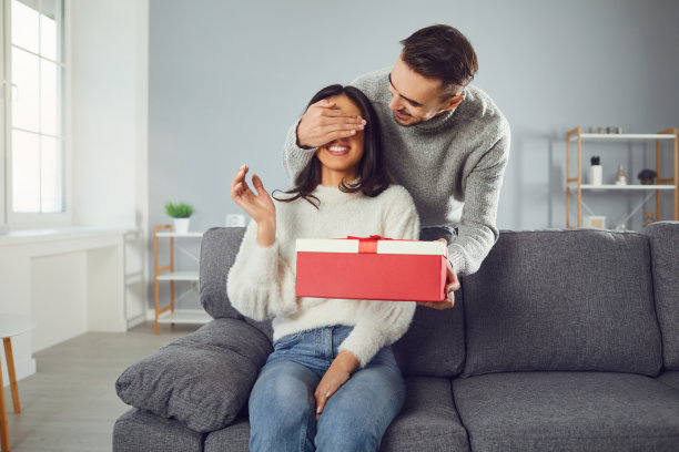 情人节。一对年轻夫妇在房间里赠送礼物图片下载