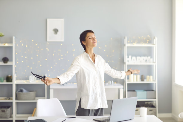 快乐放松的商业女性做呼吸练习休息期间在她的家庭办公室图片下载