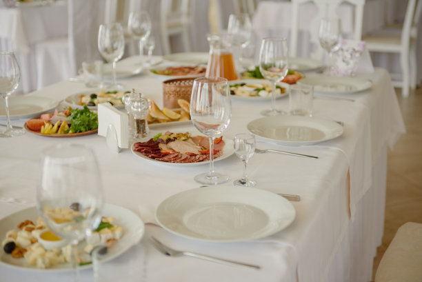 准备好酒杯，盘子和餐具，复印空间。婚宴场地设置。餐厅婚宴餐桌图片下载