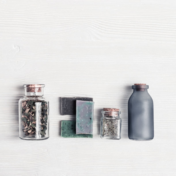 创意俯视图布局与浴室配件，有机DIY肥皂和小罐子与天然成分。天然手工肥皂在白色木质背景与复制空间。平的。图片下载