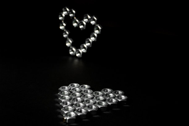 六角螺栓心型平躺与站心在背景。图片下载