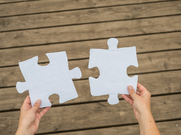 白色拼图片放在胡桃木桌上，选择性聚焦。图片下载