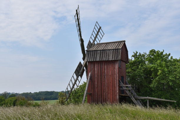 传统古老的风车在一片绿色景观中图片下载