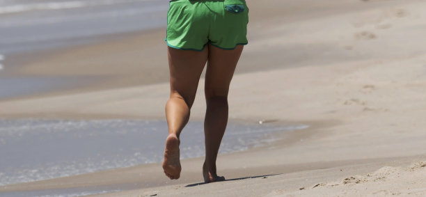 在沙滩上跑步者的腿部后视图图片下载