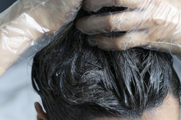 特写女人的手染头发。在家里用灰色的发根染深色头发的中年妇女图片下载