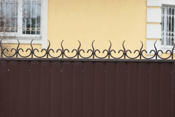 金属栅栏的一部分，上面有锋利的棕色杆和锻造的图案图片下载