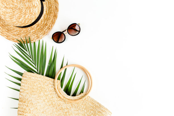 生态藤袋，草帽和热带棕榈叶。旅行者配件概念上的白色背景。夏天的背景。平躺，俯视图图片下载
