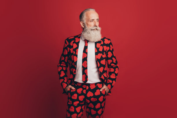 自信的大胡子男子的照片，手口袋，酷的看一边空的空间穿心印礼服孤立的红色背景图片下载