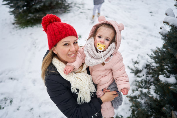 快乐的母亲和女儿享受第一天的雪图片下载