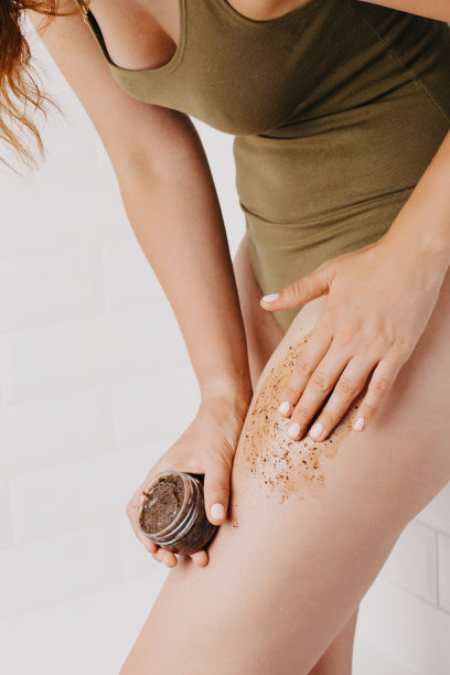 女人在浴室里使用身体磨砂膏。图片下载