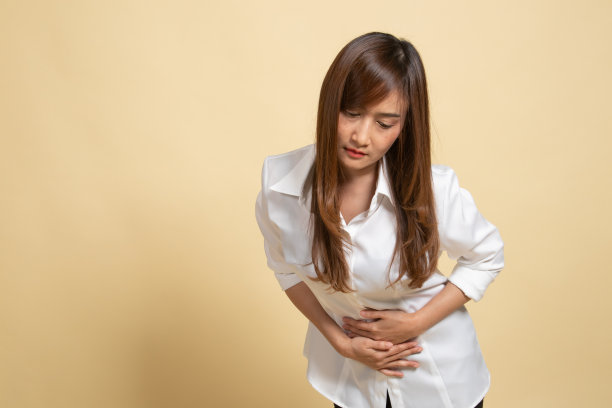 一位年轻的亚洲妇女胃痛。图片下载
