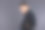 一名穿着黑色衬衫、坐在真皮椅子上、灰色背景的时尚男子看着摄像机。档案照片。图片下载