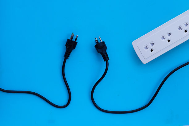 蓝色背景上带插头的电源条。俯视图图片下载