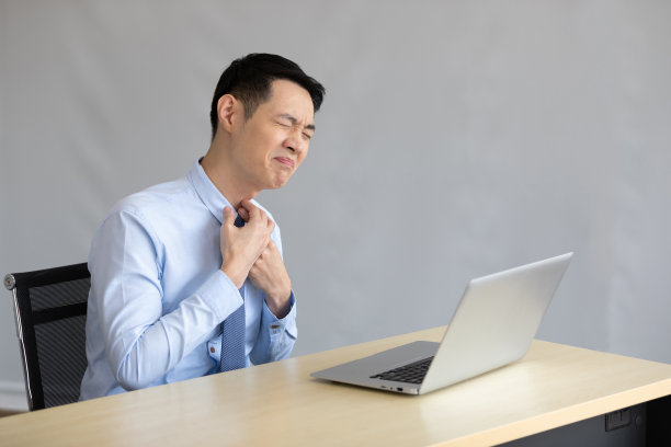 亚洲年轻商人在办公室里喉咙痛图片下载