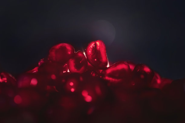 黑色背景上的红色。石榴籽、水果、食品。有选择性的重点。宏。副本的空间。抽象。图片下载