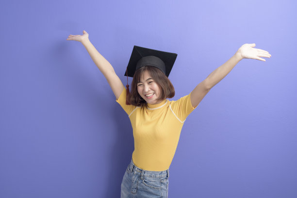 年轻的亚洲学生的肖像戴毕业帽在工作室背景。图片下载