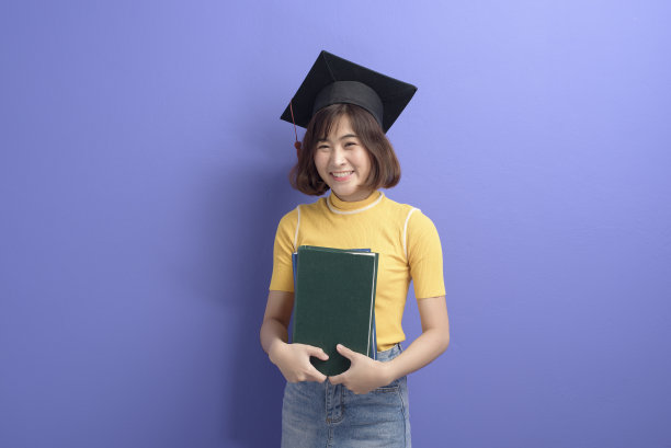 年轻的亚洲学生的肖像戴毕业帽在工作室背景。图片下载