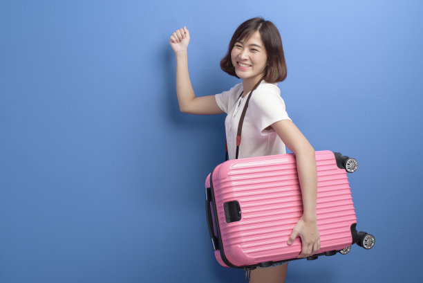 年轻的女旅行者肖像孤立在紫色的背景工作室。图片下载