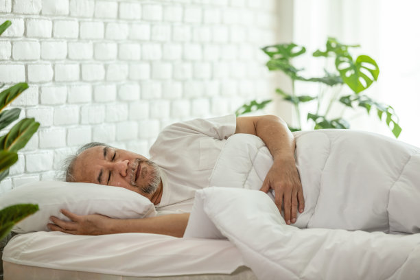 亚洲老人闭上眼睛微笑睡觉和甜蜜的梦在卧室的床上在早上感觉如此放松和舒适，保健和睡眠的概念图片下载