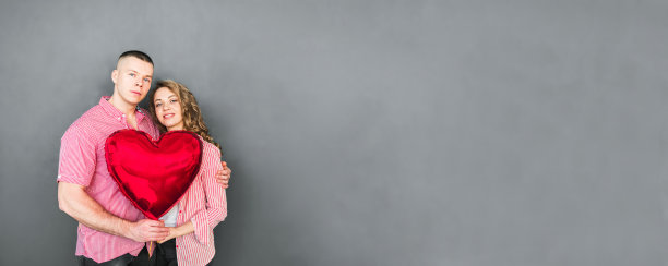 年轻的夫妇拥抱着，手里拿着一个红色的气球图片下载