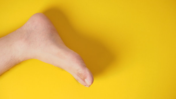 光脚的男性被隔离在黄色背景上。图片下载