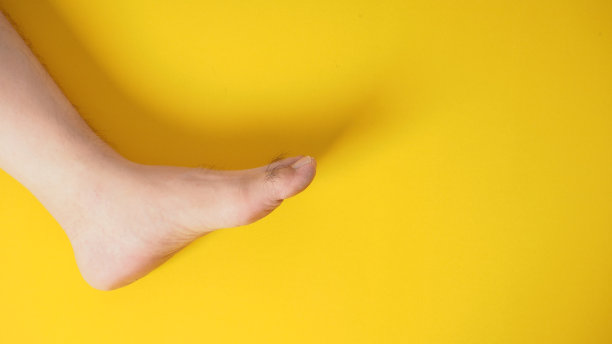 光脚的男性被隔离在黄色背景上。图片下载