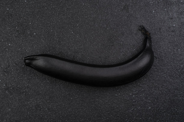 黑色的香蕉在黑暗的背景。创造性的成分。图片下载