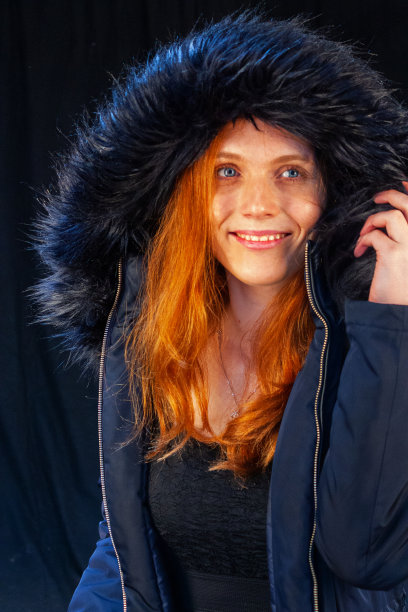 可爱的红发少年微笑着，穿着深蓝色的冬大衣，披着毛皮披肩，望着远方图片下载
