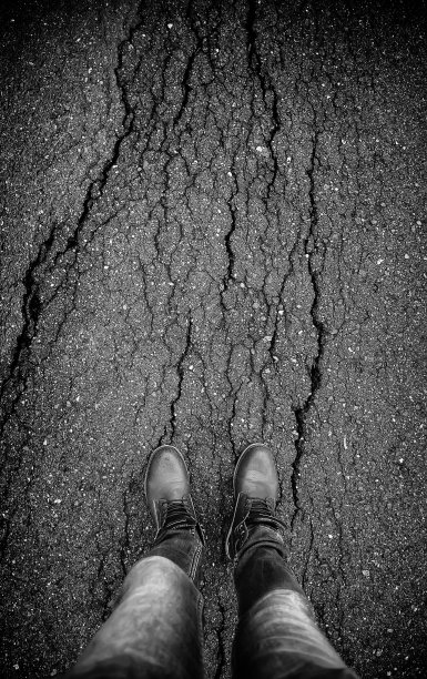 脚踩在开裂的沥青上图片下载