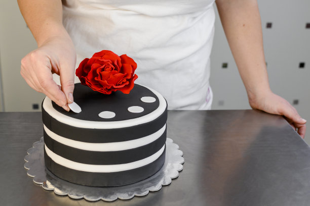 面包师用白点装饰蛋糕。图片下载